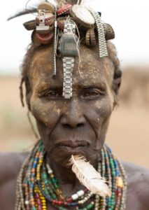 Ethiopia, Omo Valley, Omorate, Senior Dassanech Woman Wearing Watch As Headdress And Feather In The Chin